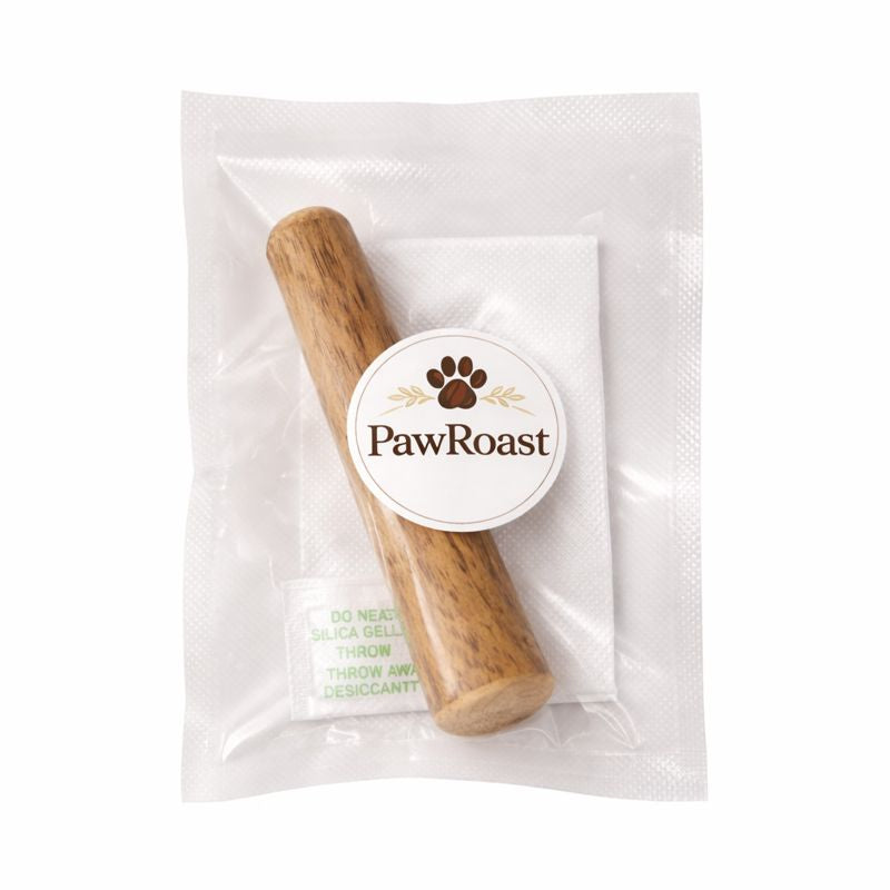 Hand holding PawRoast coffee wood dog chew - natural sustainable pet product